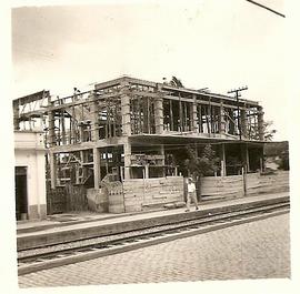 Vista externa da construção do Cine Idelmar, com detalhes do trilho do trem em frente à construção